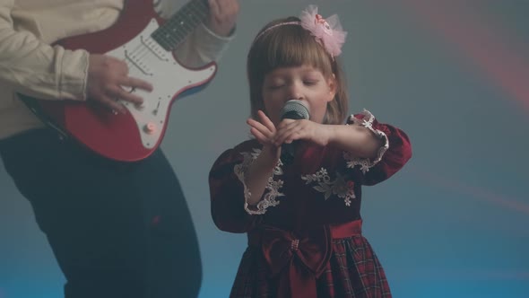 Little Girl in Vintage Dress Sings on Stage Her Father Plays an Electric Guitar alt