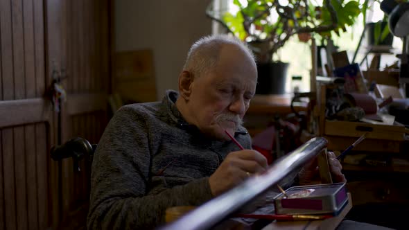 Elderly Male Master Works in His Workshop Restoring Japanese Sword