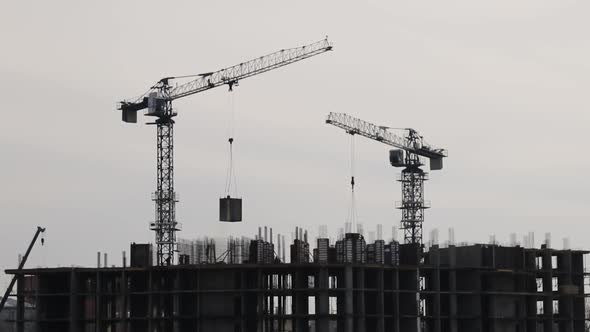 Silhouettes of Construction Cranes Working alt
