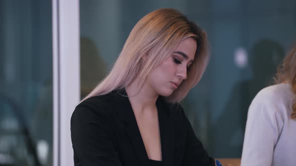 Girl Focused on Writing Information at a Meeting in the Office