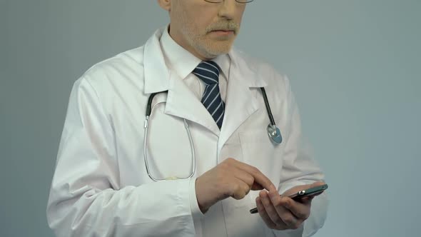 Hospital Physician Dialing Number on Smartphone, Calling to Consult Patient alt