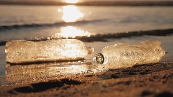Debris in the Sea  Plastic Bottles at the Edge of the Water on the Beach alt