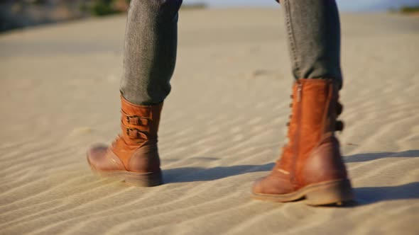 Hiker's feet in boots walking on the sand in the desert, close-up alt