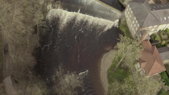 aerial drone shot of river water flowing through cascade and waterfall alt