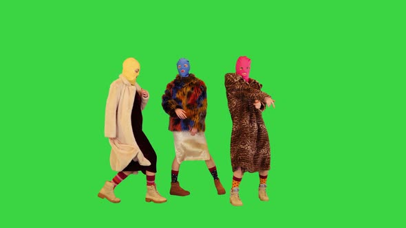Three Girls in Colored Balaclavas Come Out Dance and Walk Away on a Green Screen Chroma Key