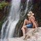 A Young Woman Admires a Beautiful View of the Waterfall - VideoHive Item for Sale