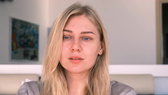 Calm Young Beautiful Blueeyed Blonde Woman Without Makeup Looks Into the Camera