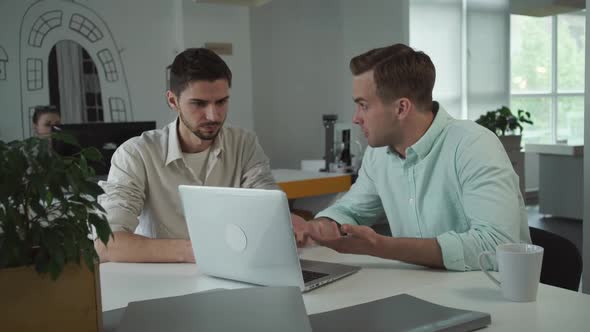 Two Young Happy Businessmen Working Together in the Office alt