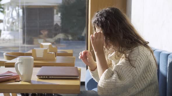 Woman Use Laptop in Cafe and Rubbing Tired Eye