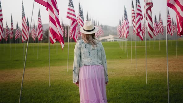 Beautiful Young Woman at with American Flags at Sunset alt