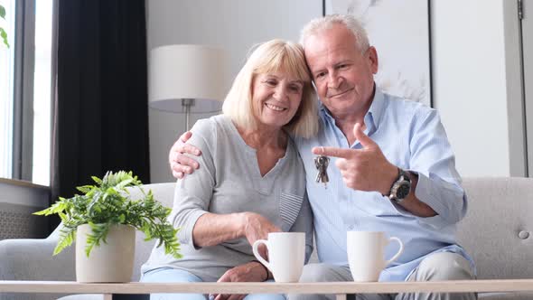 Happy Elderly Woman and Man Client Landlord Hold the Key to the New House alt