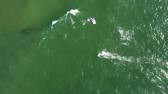 AERIAL: Top View of Kite Surfer Riding Waves on a Green Colour Baltic Sea