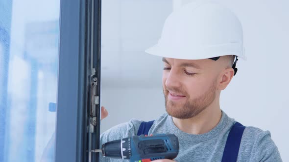 Window Installer in a Helmet and a Screwdriver Installs Windows alt