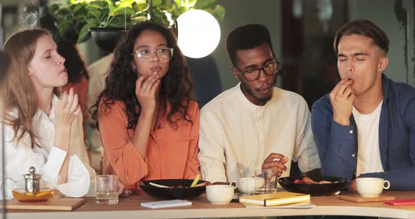 Multiracial Group of Friends Enjoing Delicious Meal While Sitting in Modern Cafe, Millennial alt