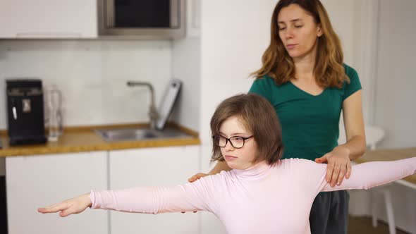 Girl with Down Syndrome and Her Mom Practicing Yoga Position at Home alt