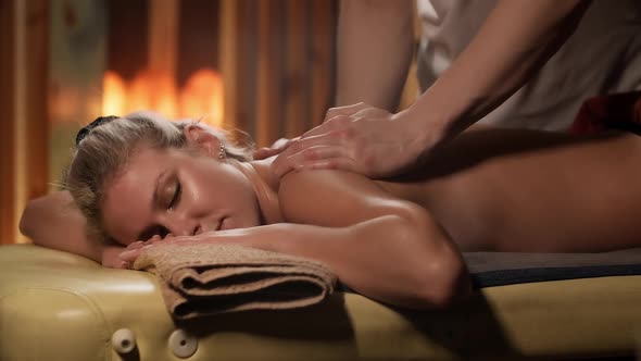 Masseur Doing Back Massage to Young Blonde Woman in Spa Centr alt