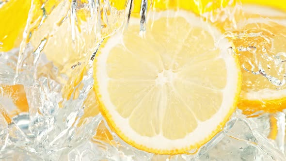 Super Slow Motion Shot of Pouring Water on Lemon Slices and Ice Cubes in Glass at 1000 Fps alt