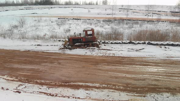 Old Bulldozer on a Snowcovered Dirt Road alt