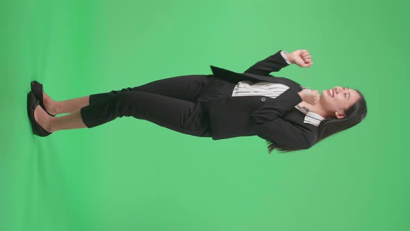 Full Side View Body Of A Smiling Asian Business Woman Dancing While On Green Screen Background alt