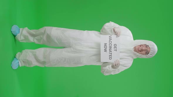Full Body Of Asian Man Wear Uniform Ppe And Holding Get Vaccinated Now Sign In Green Screen Studio alt