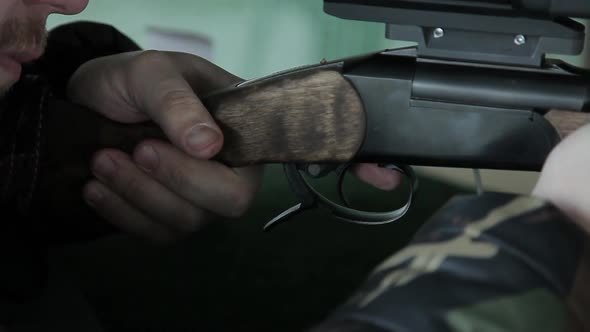 A Male Shooter Hunter Takes Aim and Pulls the Trigger of a Carbine Gun Making a Shot From a Firearm