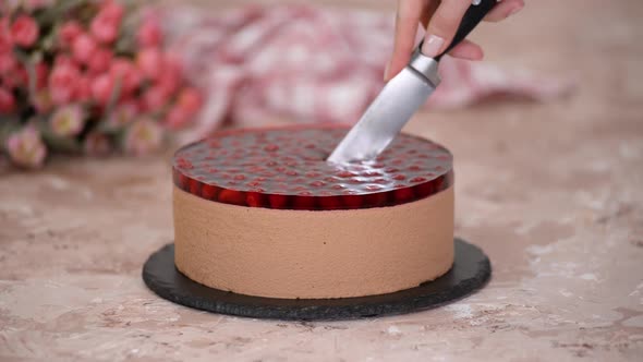 Cutting Chocolate Mousse Cake with Cherries Jelly