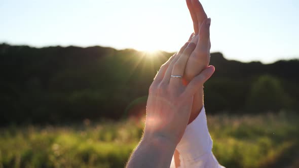Couple Hands Together Outdoors in Sunset Light alt