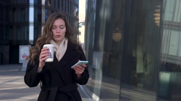 Young Caucasian Business Woman In City Walking Texting On Cell Phone