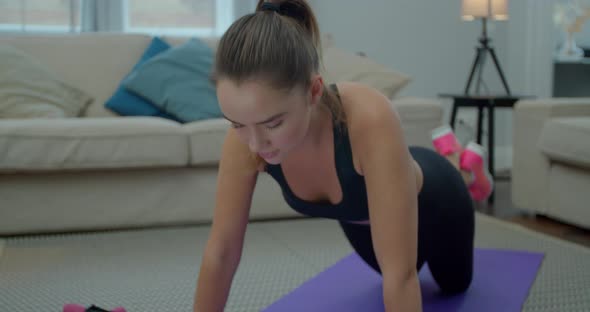 Young Sporty Woman Is Doing Push-ups Exersice at Home in Living Room. Athletic Fit Girl Is Doing alt