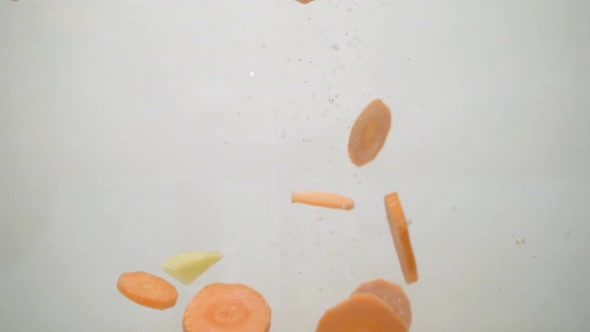 Dropping crude vegetables into the water. alt