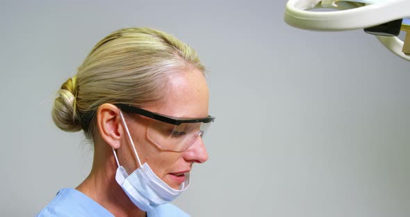 Female dentist assisting male patient to wear virtual reality headset alt