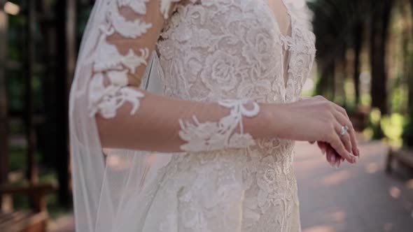 hands of the bride on a beautiful wedding dress