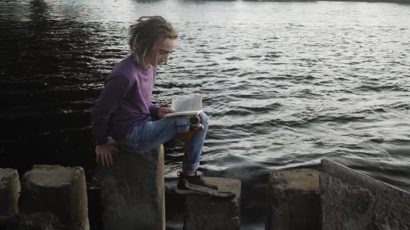 Man with Leg Prosthesis Reads Textbook Sitting on Stairs alt