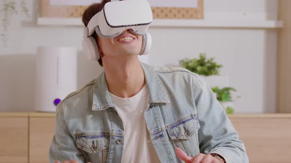 Asian man using VR virtual reality glasses headset excite and amazing in metaverse. Young man goggle alt