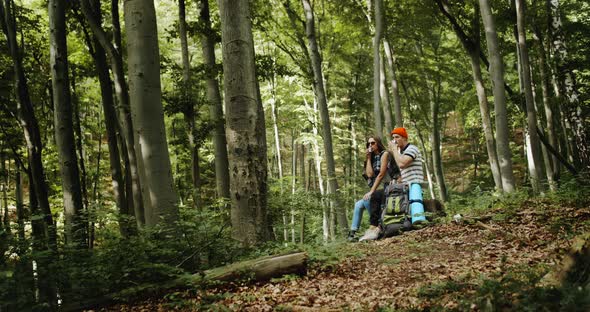 Couple of Tourists Resting with Tea in Forest