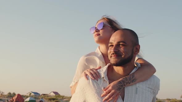 Young Beautiful Couple in Love Standing and Hugging on Beach By the Sea