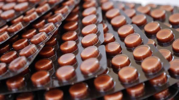 macro shot of brown colored tablets. close rotating shot of brown colored packets alt