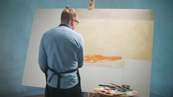 Creative Person at Work a Talented Male Artist Draws an Abstract Picture on a Large Canvas Slow alt