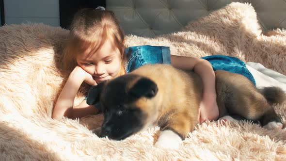 Cheerful girl laying on bed near her pet