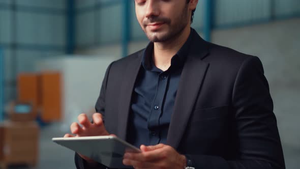 Factory Manager Using Tablet Computer in Warehouse or Factory alt