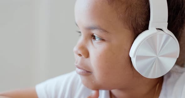 Afro American Kid Girl School Pupil Wearing Headphones Studying Online From Home Watching Web Class alt