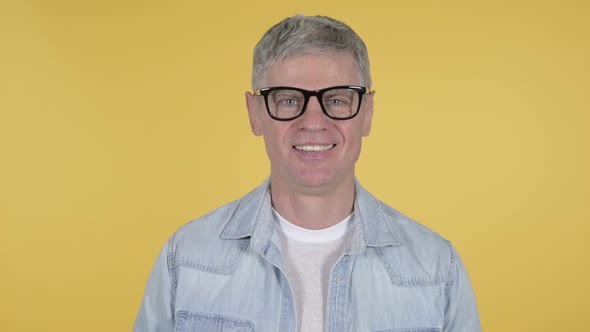 Smiling Casual Senior Man Isolated on Yellow Background alt