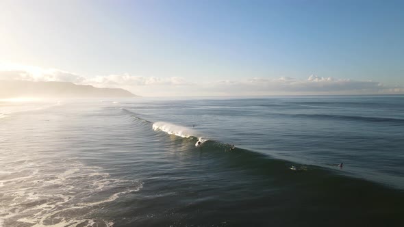 drone shot of surfer riding a large wave during sunrise in Costa Rica alt