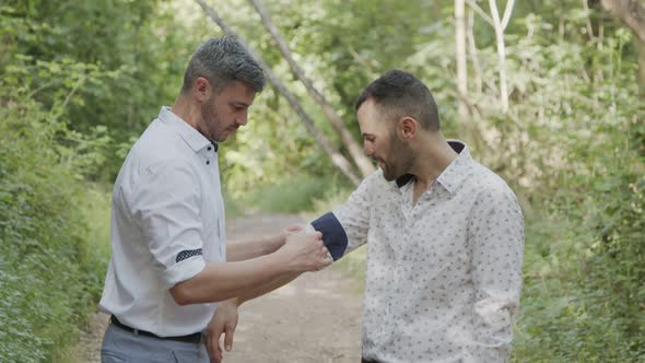 Gay couple during a photo shoot before their wedding in a forest alt