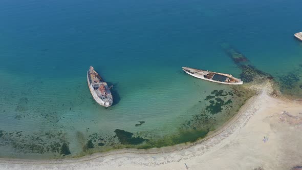 A Wrecked Wooden Ship Lies on the Seashore Covered with Rust alt