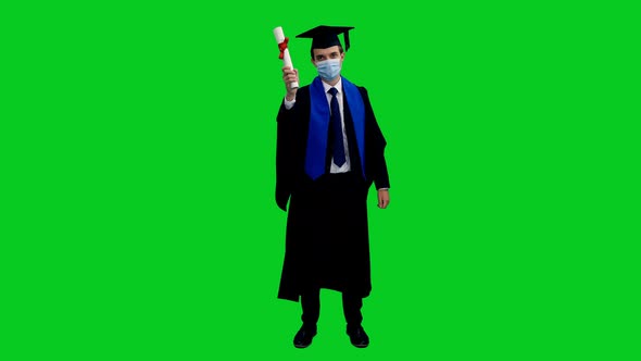 Graduating Student In Protective Mask Showing Thumbs Up And Diploma