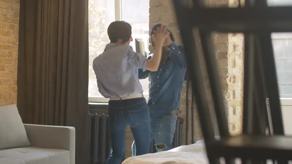 Cheerful Young Interracial Couple Dancing in Bedroom and Smiling. Positive African American Man and alt