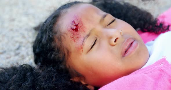 Unconscious girl fallen on ground after accident alt