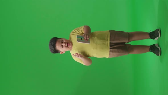 Full Body Of Young Asian Little Boy Surprise And Say Wow During Use Mobile Phone On Green Screen alt