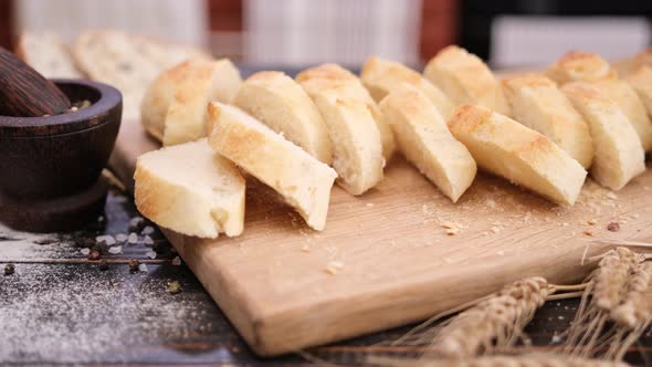 Sliced Fresh Baguette Bread on Wooden Cutting Board alt